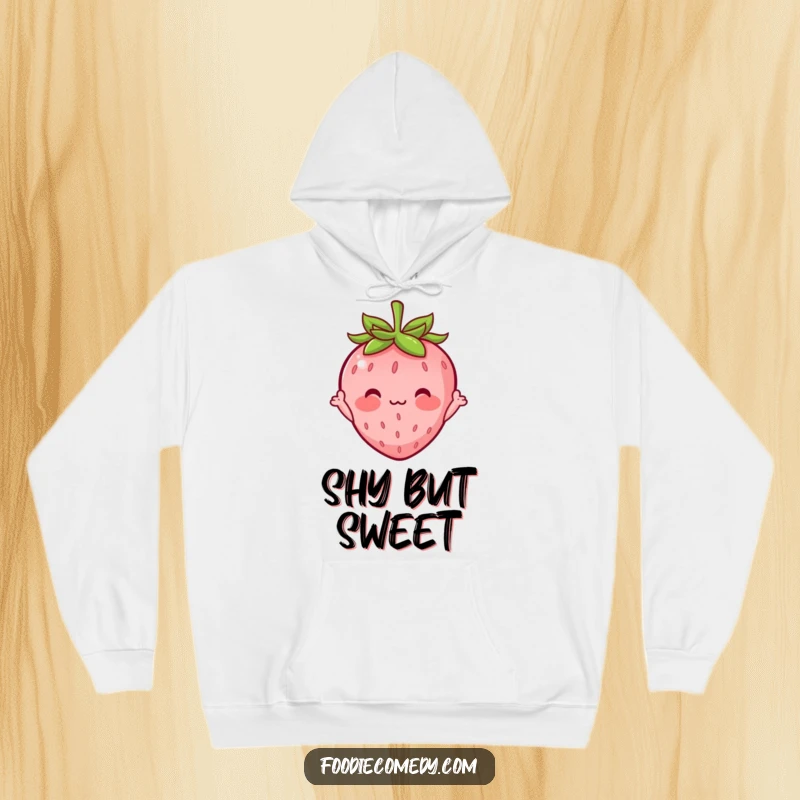 Funny hoodie with a blushing strawberry character, tiny arms waving shyly, exuding shyness and charm for a cozy, humorous look.