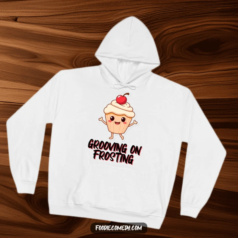 Funny hoodie showcasing a smiling cupcake character with a cherry, caught mid-dance, exuding joy and cozy vibes.